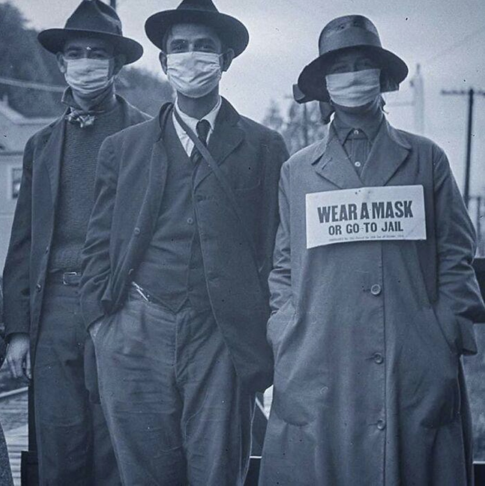 3 people pose for a photo while wearing face masks during the second wave of the Spanish Flu in California, 1918